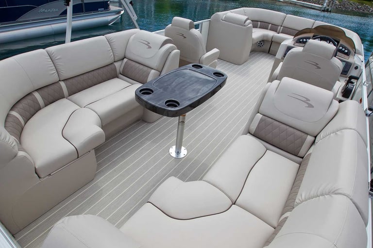 Spacious boat deck with beige seating, center table, and water view in background